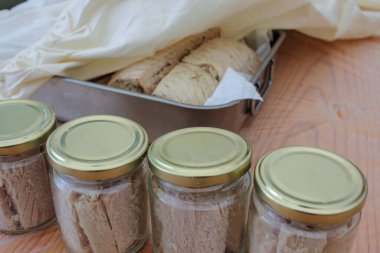 the process of preserving white tuna in glass jars with olive oil in a traditional way in Burela, Spain