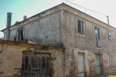 Kırsalda bulutlu gökyüzünün altında harabeler içinde eski bir ev.