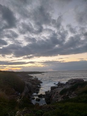 İspanya, A Marina 'da bulutlarla denizin üzerinde gün batımı