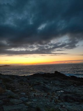 İspanya, A Marina 'da bulutlarla denizin üzerinde gün batımı