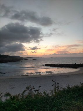 İspanya, A Marina 'da bulutlarla denizin üzerinde gün batımı