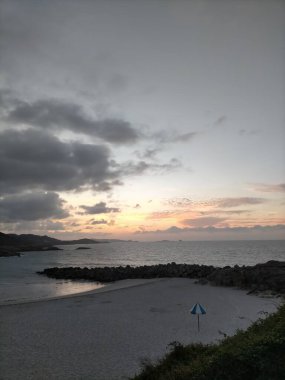 İspanya, A Marina 'da bulutlarla denizin üzerinde gün batımı