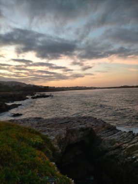 İspanya, A Marina 'da bulutlarla denizin üzerinde gün batımı