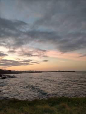 A Marina, Galiçya, İspanya 'da bulutlarla denizin üzerinde gün batımı