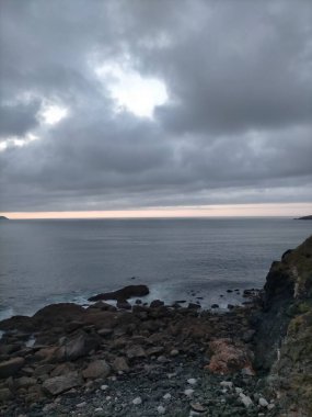 A Marina, Galiçya, İspanya 'da bulutlarla denizin üzerinde gün batımı