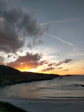 Deniz üzerinde ve bulutların altında gün batımı renkleri