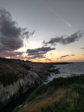 Deniz üzerinde ve bulutların altında gün batımı renkleri