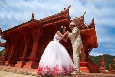 Wedding couple in Taisky style, Taisky architecture, a loving couple, wedding suits