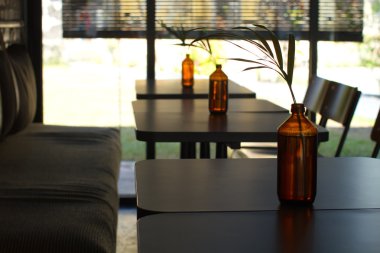 Su ile cam şişe, Kahverengi şişe, su ile bir cam bardak, bir masada bir çiçek