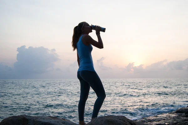 The beautiful girl sitting on stones and looking in a distance, the girl at sunset to meditate in silence, beautiful telo.concept .Siluet lonely girl sitting on the precipice of a cliff at sunset. — Stock Photo, Image