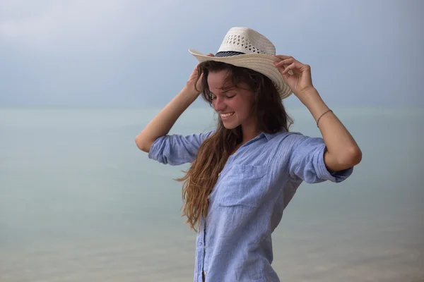 Красива дівчина в капелюсі на шипіння, на тропічному пляжі, з посмішкою на обличчі — стокове фото