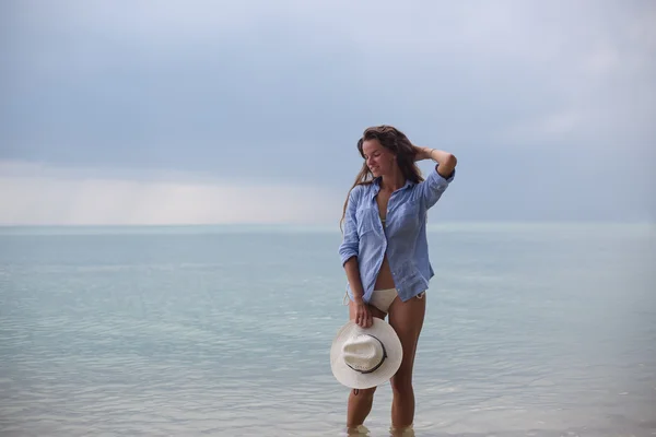 Красива дівчина в капелюсі на шипіння, на тропічному пляжі, з посмішкою на обличчі — стокове фото
