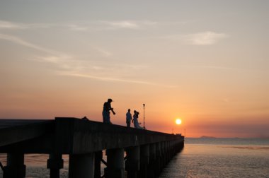 adam bir iskelede insanlar gün batımında fotoğraf arşivi