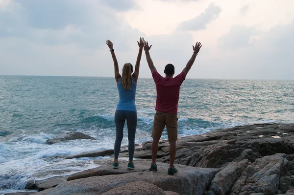 Outdoor summer portrait of young romantic couple in love posing at amazing stone beach, travel together hugs and having fun. — Stock Photo, Image