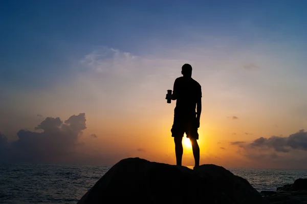 The man drinks from a bottle at dawn — Stock Photo, Image