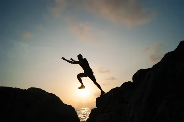 L'uomo che salta sulle rocce — Foto Stock