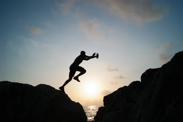 L'uomo che salta sulle rocce — Foto Stock