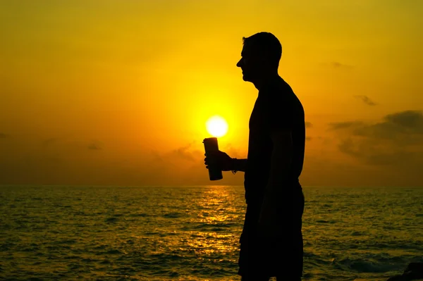 The man drinks from a bottle at dawn — Stock Photo, Image