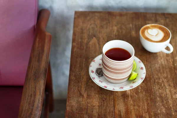 女の子のカフェでコーヒーや紅茶があります。Kofy、テーブルの上の紅茶を 100 レクと木製の小さなテーブルにある別の花、白、カボチャ、黄色カボチャ、オレンジ色のかぼちゃのカボチャ。テーブルと 2 つの円の本 — ストック写真