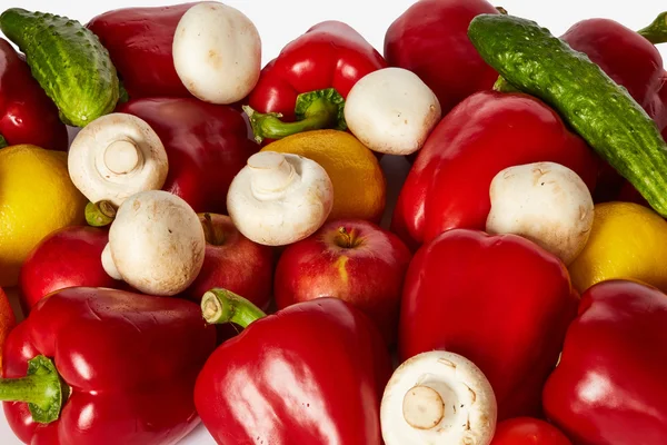 Beyaz bir arka plan üzerinde pek çok sebze, meyve ve mantar vardır