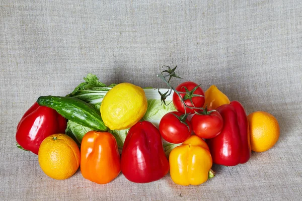 Gemüse, Obst und Zitrusfrüchte liegen auf einer grauen Leinwand — Stockfoto