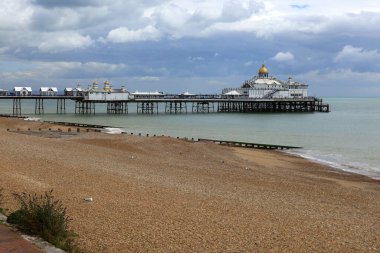 Eastbourne Rıhtımı, plaj ve İngiliz Kanalı manzaralı fotoğraf. Eastbourne, İngiltere 'de fırtınalı bir gökyüzüne karşı.