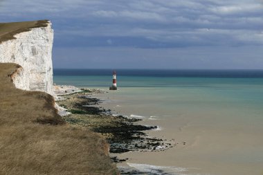 Tebeşir kayalıkları, Beachy Head Deniz feneri ve İngiliz Kanalı kıyı şeridi manzaralı manzara fotoğrafı Eastbourne, İngiltere yakınlarındaki fırtınalı bir gökyüzüne karşı