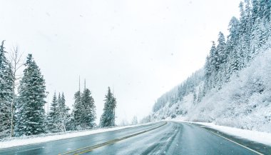 Empty road with snow covered landscape in winter season. clipart