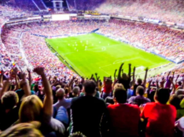 Football- soccer fans support their team and celebrate goal in full stadium with open air with nice sky.-blur picture. -blurred..