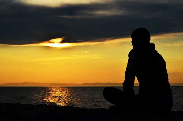 Girl sitting on the shore of the lake — Stock Photo, Image