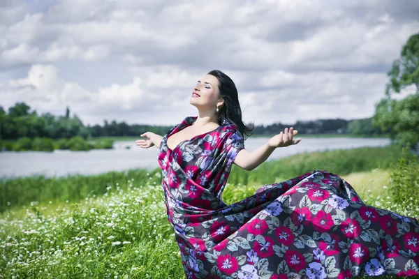 Naturliebe Frau auf Blumenfeld gekleidet in buntes Tuch — Stockfoto