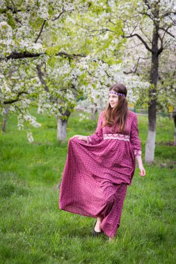 Modeli şehrin içinden yürüyerek geçer. Dantel ile güzel uzun Kırmızı elbiseli uzun saçlı genç kız