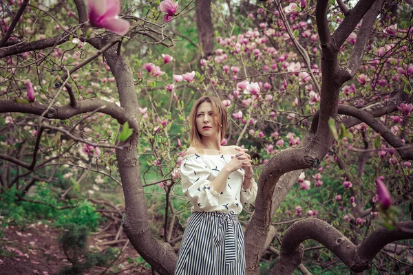 피에 젊은 아름 다운 백인 여자 봄 태산목의 정원. 흐린 날에 정원에 있는 여자 . — 스톡 사진