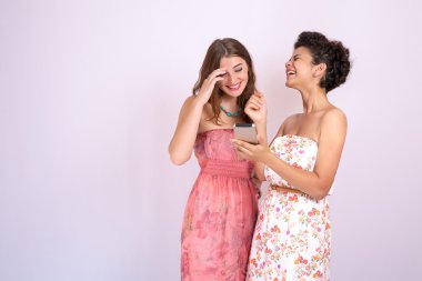 İki kız arkadaşım elinde bir smartphone ile gülüyor. Teknoloji, Internet, iletişim