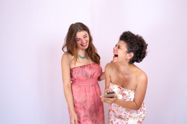 İki kız gülen ve having fun arkadaşlar akıllı telefon arıyor. Teknoloji, Internet, iletişim