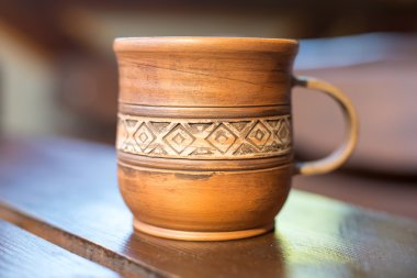 Kırmızı kil ahşap masa portre üzerinde ulusal süsleme ile bir fincan