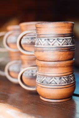 Kırmızı kil ahşap masa portre üzerinde ulusal bir süsleme ile bardak