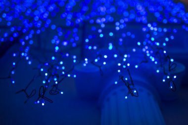 Koyu mavi arka planda fotokopi alanı olan Noel ışıkları. Dekoratif çelenk