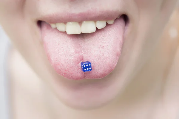 Piercing στη γλώσσα των κοριτσιών όπως μπλε ζάρια για το παιχνίδι — Φωτογραφία Αρχείου
