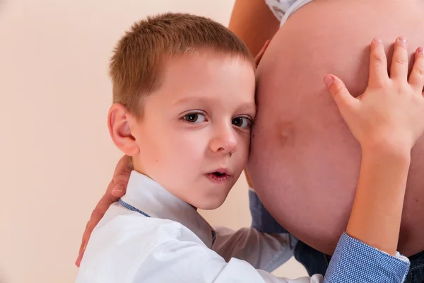 Kleiner Junge lauscht Schwangerschaftsbauch — Stockfoto