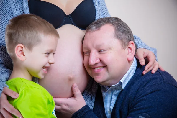 Niño y papá escuchando el vientre de la madre embarazada —  Fotos de Stock