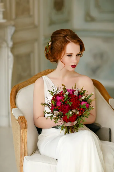 Very pretty sophisticated red-haired girl sitting in a chair wit — Stock Photo, Image