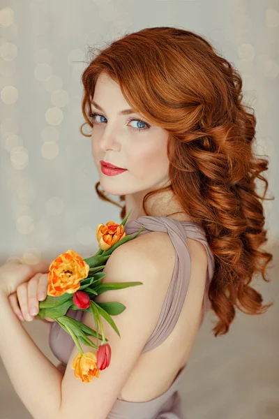 Portrait of a beautiful red-haired girl with blue eyes holding a — Stock Photo, Image
