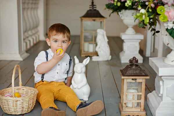 Маленький хлопчик в жовтих штанях сидить на підлозі в інтер'єрах — стокове фото