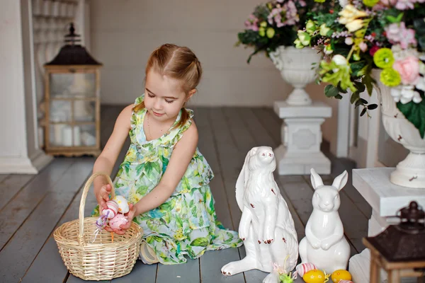 Charmante meisje met pigtails in een groene jurk zittend op t — Stockfoto