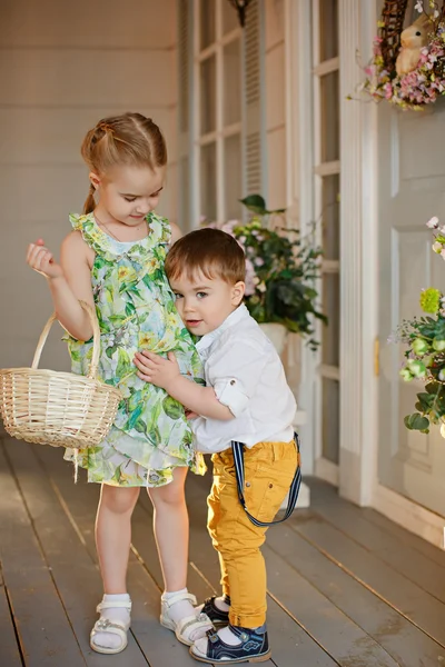 Hermana con un vestido verde y su hermano menor, están abrazando i — Foto de Stock