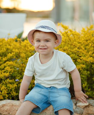 Bir şapka ve yaz şort küçük bebek çocuk park bac üzerinde sly gülümseme