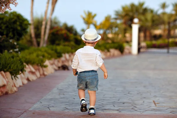 Kleine baby jongen in een hoed en shorts gaat vooruit in de zomer, Bekijk f — Stockfoto