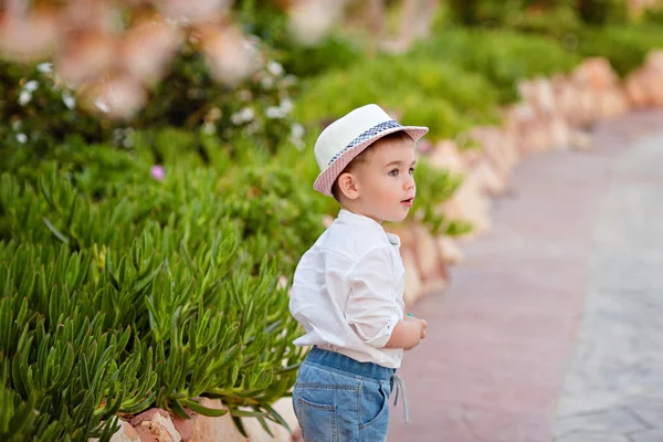 Menino em um chapéu e calças curtas no verão em um backgroun — Fotografia de Stock