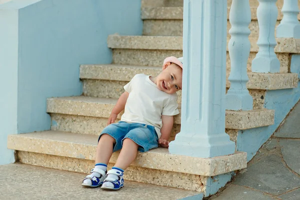 Kleine baby jongen in de hoed zittend op de trappen van het huis in — Stockfoto